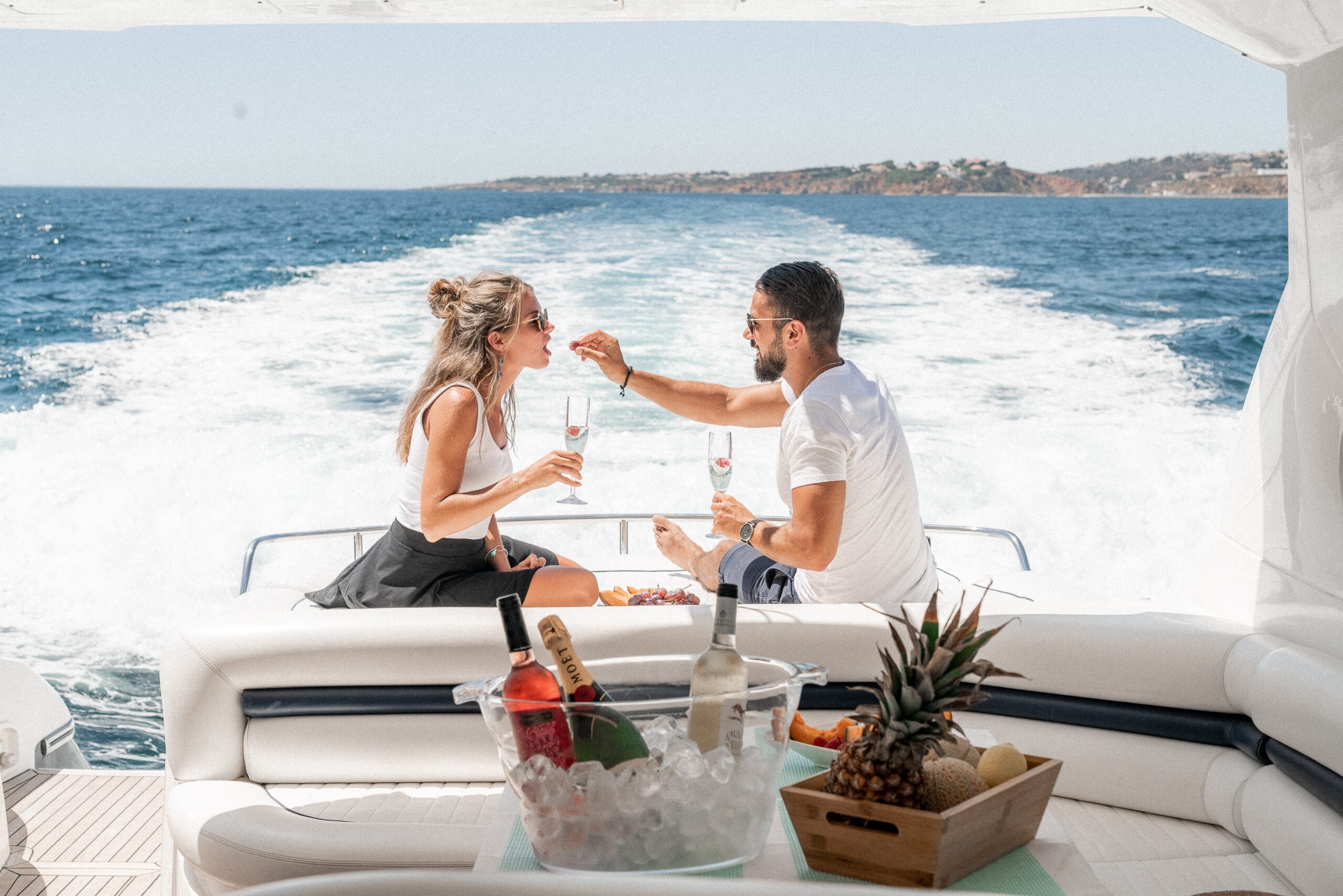 A couple enjoys a glass of champagne on a yacht.